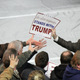 A Trump campaign staffer hands out posters in Muscatine, Iowa.
